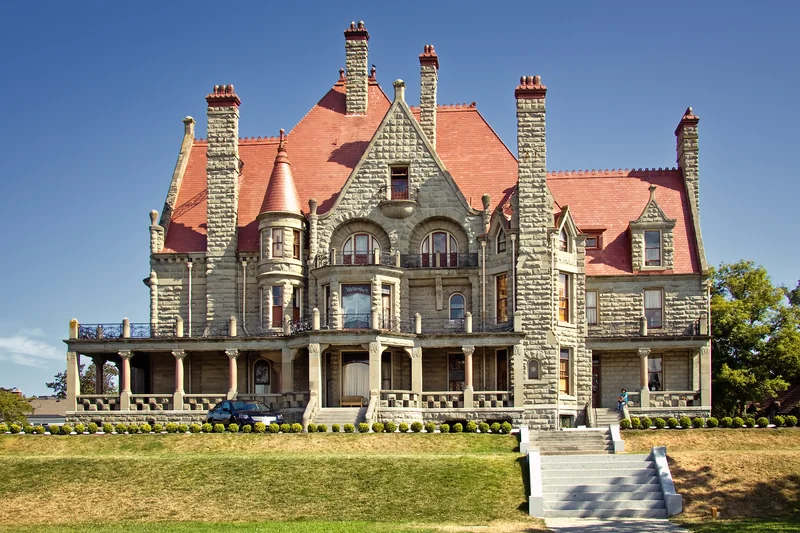 Craigdarroch Castle with its stone towers, red roofs and landscaped grounds